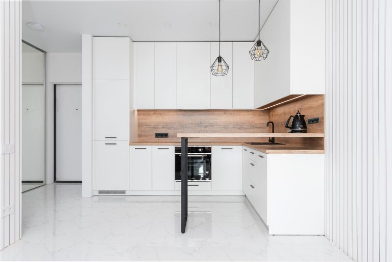 Contemporary kitchen with neutral cabinets and wood accents