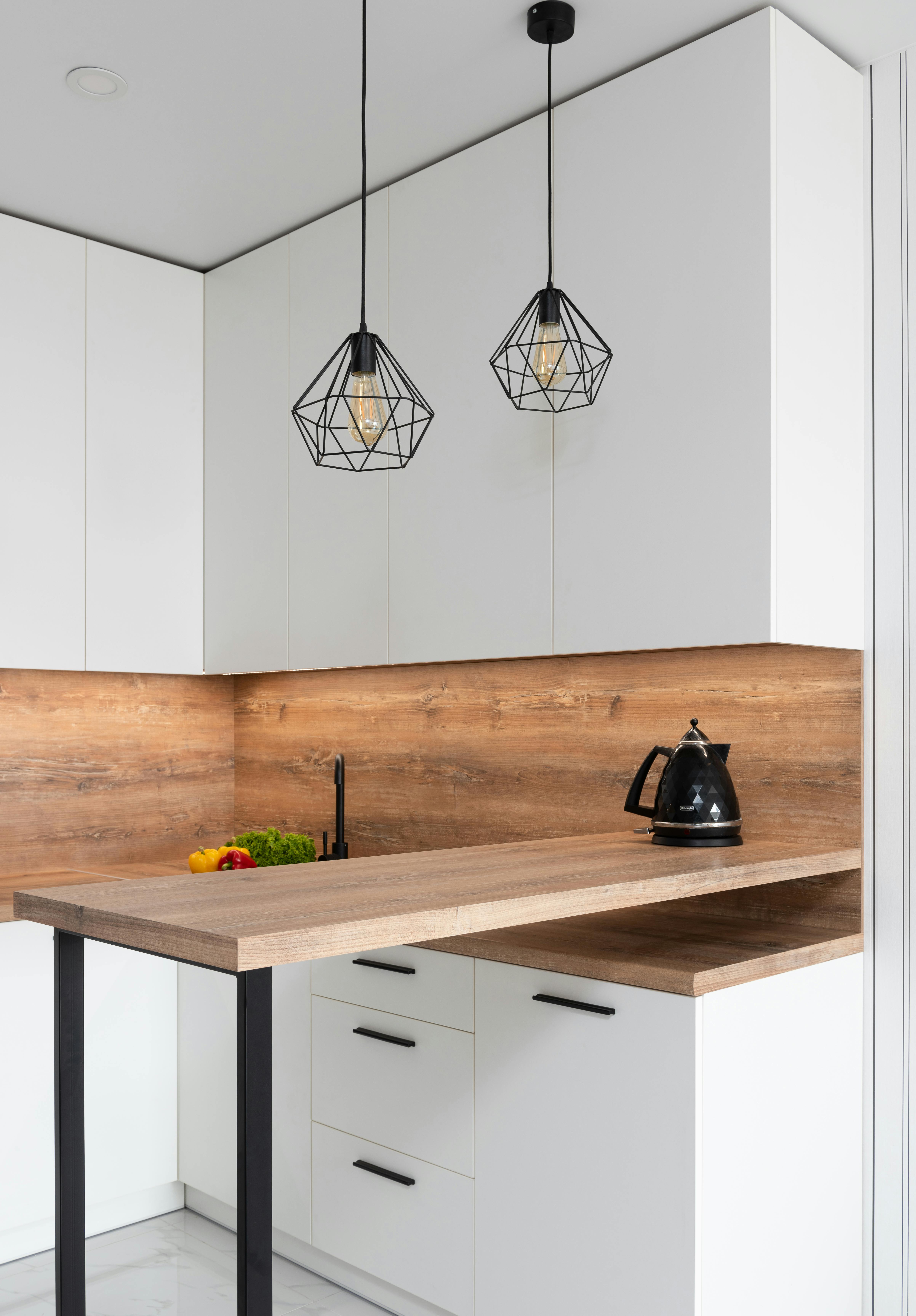 geometrical shimmering lamps hanging over wooden table of kitchen