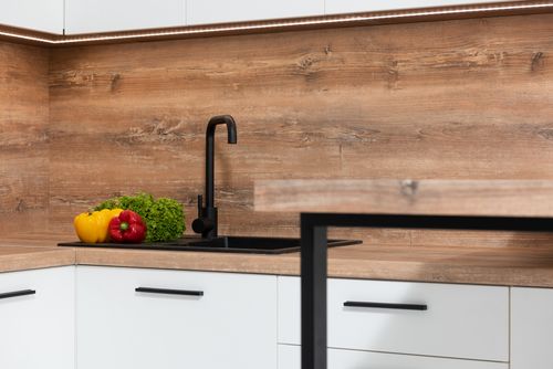 Free Interior of contemporary kitchen with black sink and fresh green lettuce with colorful bell peppers Stock Photo