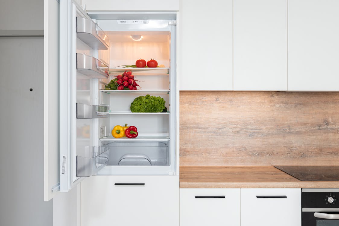 Free Fridge with different vegetable in modern kitchen Stock Photo