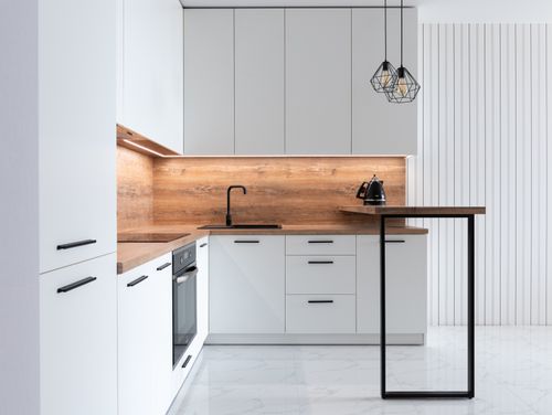 Free Contemporary interior of modern kitchen with comfortable white furniture and geometrical lamps hanging on ceiling Stock Photo