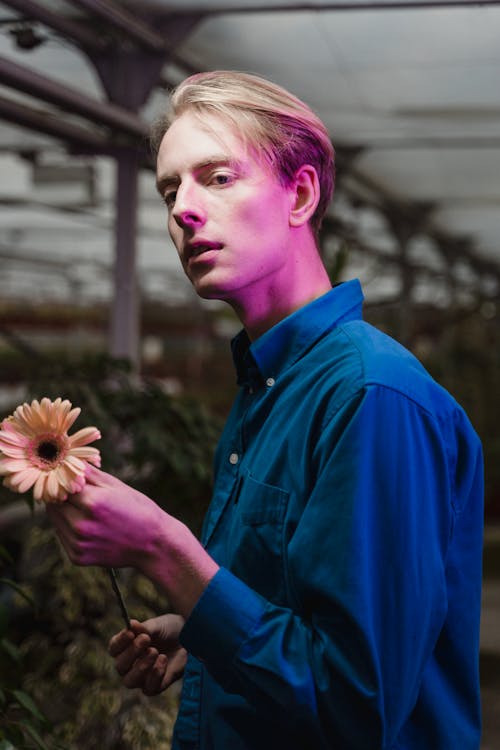 Man in Blue Long Sleeves holding a Flower