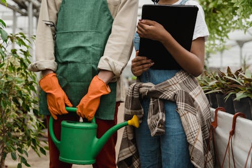 Person in Green Long Sleeve Shirt Holding Green Watering Can