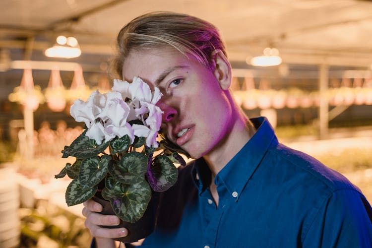 Man Holding White Flowers Looking At The Camera 