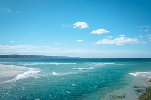 Breathtaking view of vast turquoise sea waving peacefully under cloudless blue sky on sunny day in tropical resort