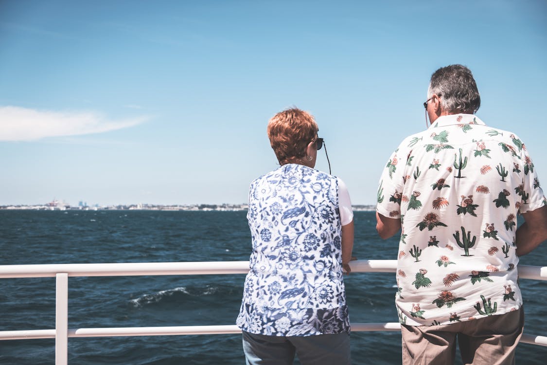 Free Anonymous mature couple recreating on boat deck during cruise in sea Stock Photo
