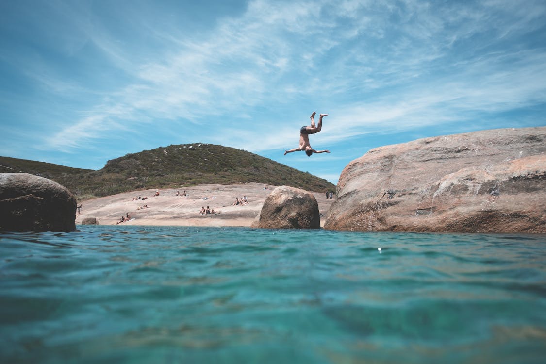Free Anonymous man jumping into ocean during summer vacation Stock Photo