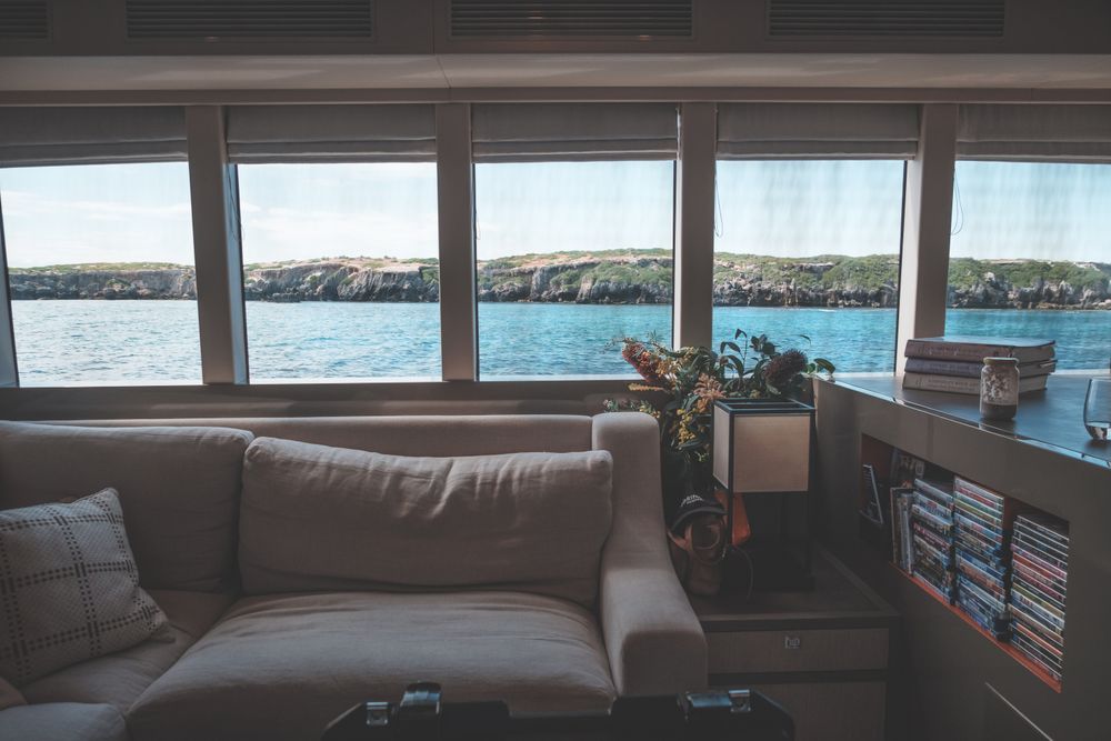 Rae 62 — saloon with sofa and panoramic sea-view windows