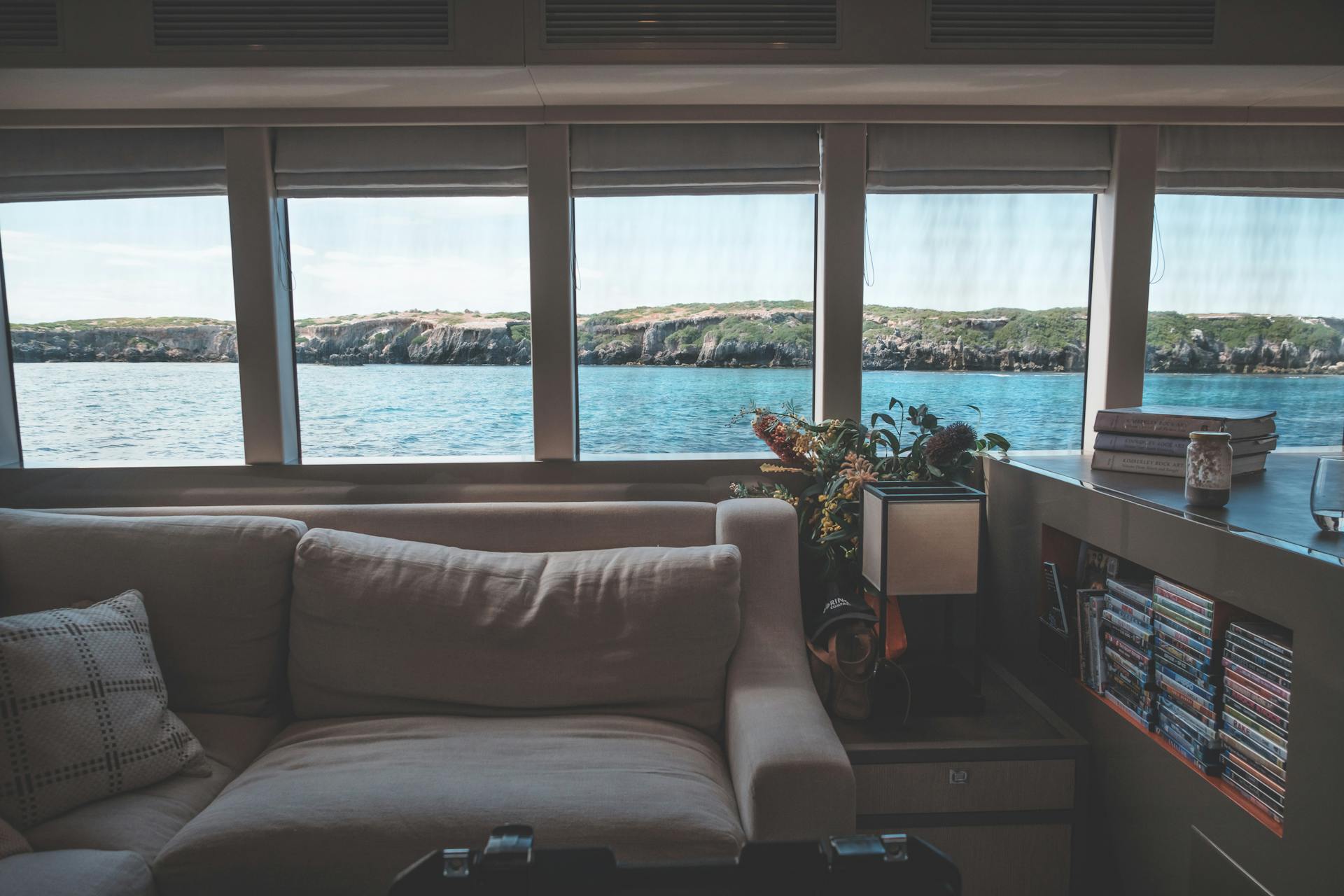 Elegant yacht interior with ocean view and cozy seating, perfect for a luxurious maritime escape.