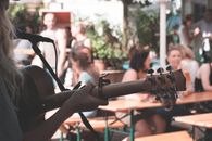 Crop guitarist performing song on street during festival