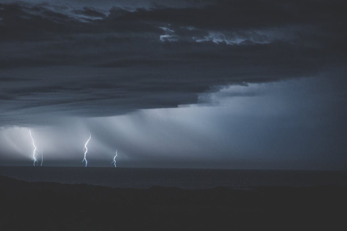 Free Thunderstorm with glimmering lightnings over ocean Stock Photo