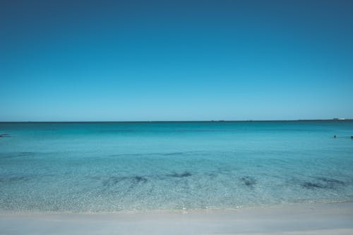 Peaceful azure sea under cloudless bright blue sky