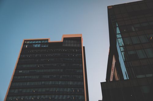 Free From below of contemporary tall buildings with glass exteriors under cloudless blue sky Stock Photo