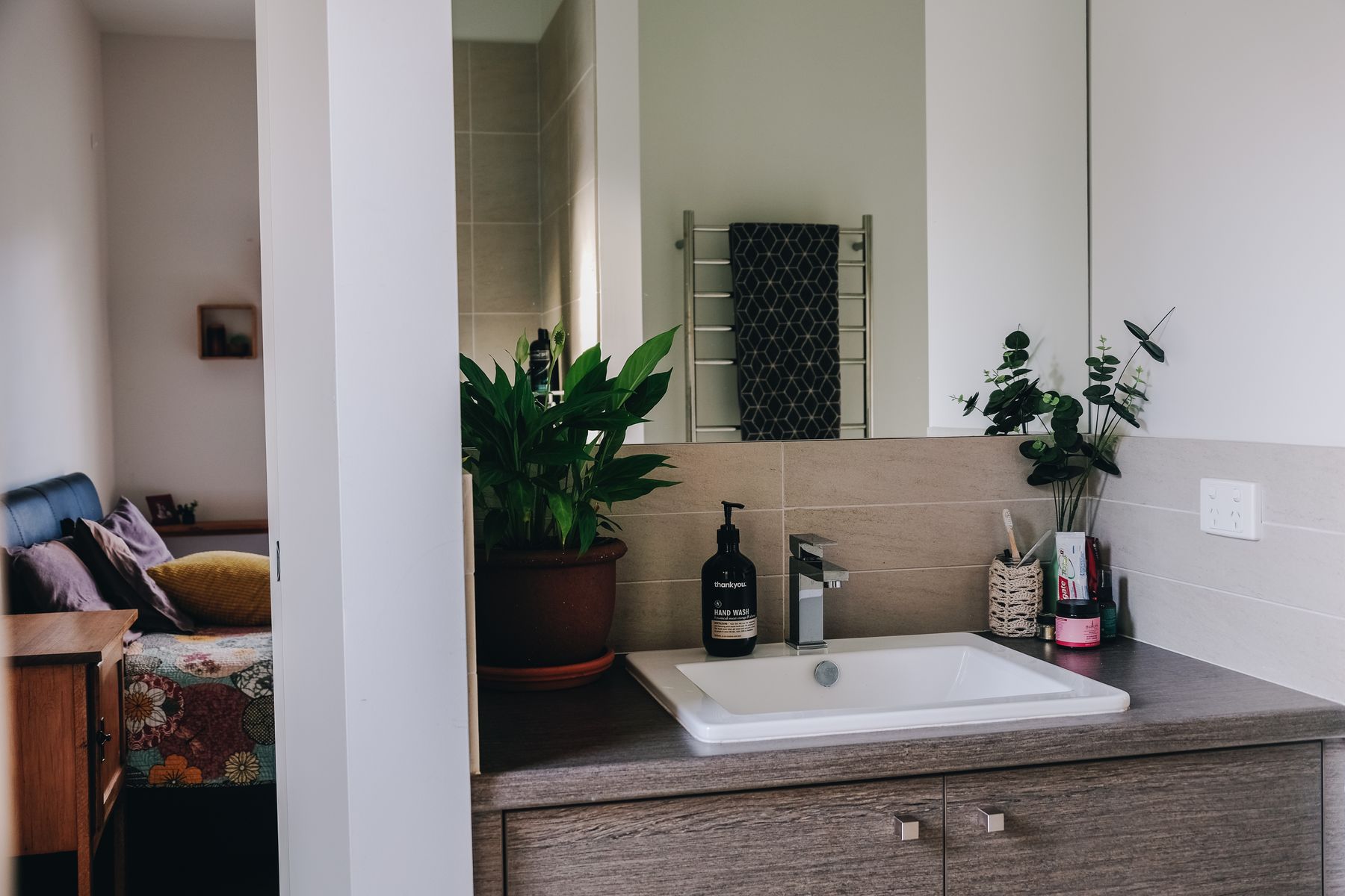 Bathroom with wood cabinet providing closed storage for larger supplies