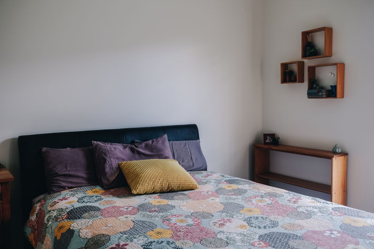 Colorful throw styled on a bed with pillows
