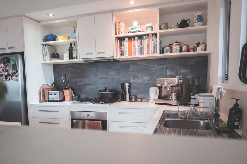Modern kitchen with minimalist furniture and appliances in a flat with clean lines and white cabinetry