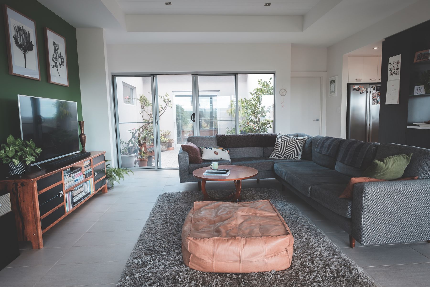 Deep textured rug beneath a soft ottoman in a restrained contemporary seating area
