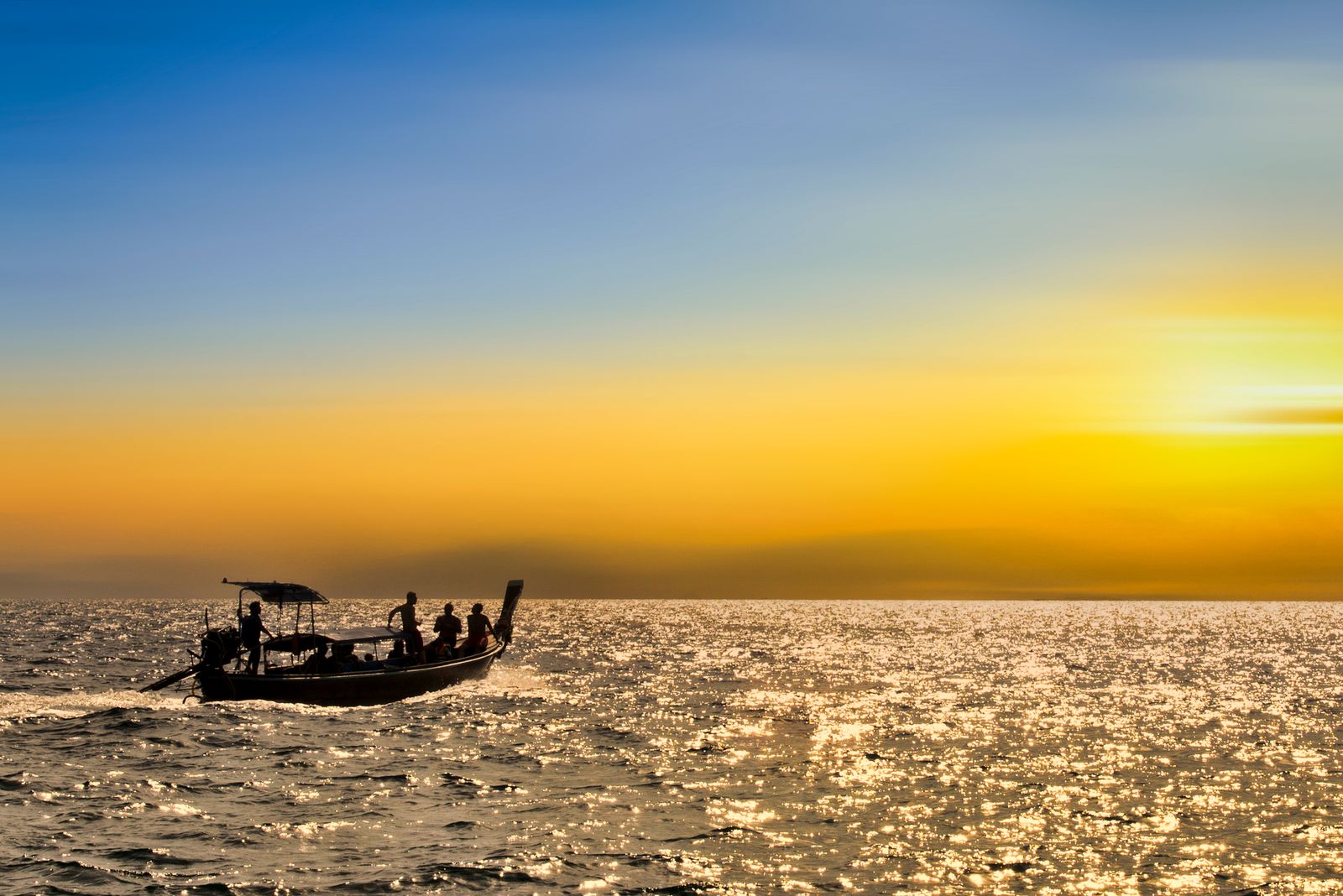 A longtail boat silhouetted against the glowing sky over the Gulf of Thailand, Koh Samui