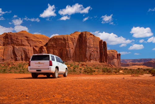 White Vehicle Parked Near Canyons Under Blue Sky