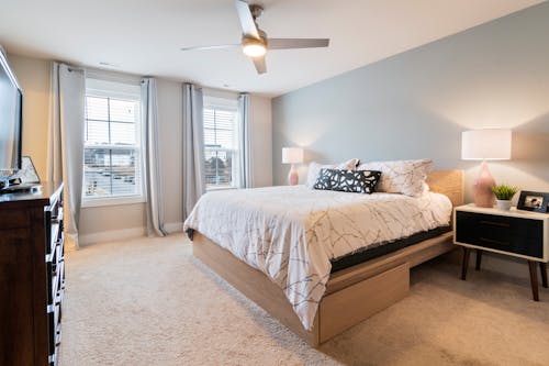 Platform Drawer Bed with White Linen in a Carpeted Room