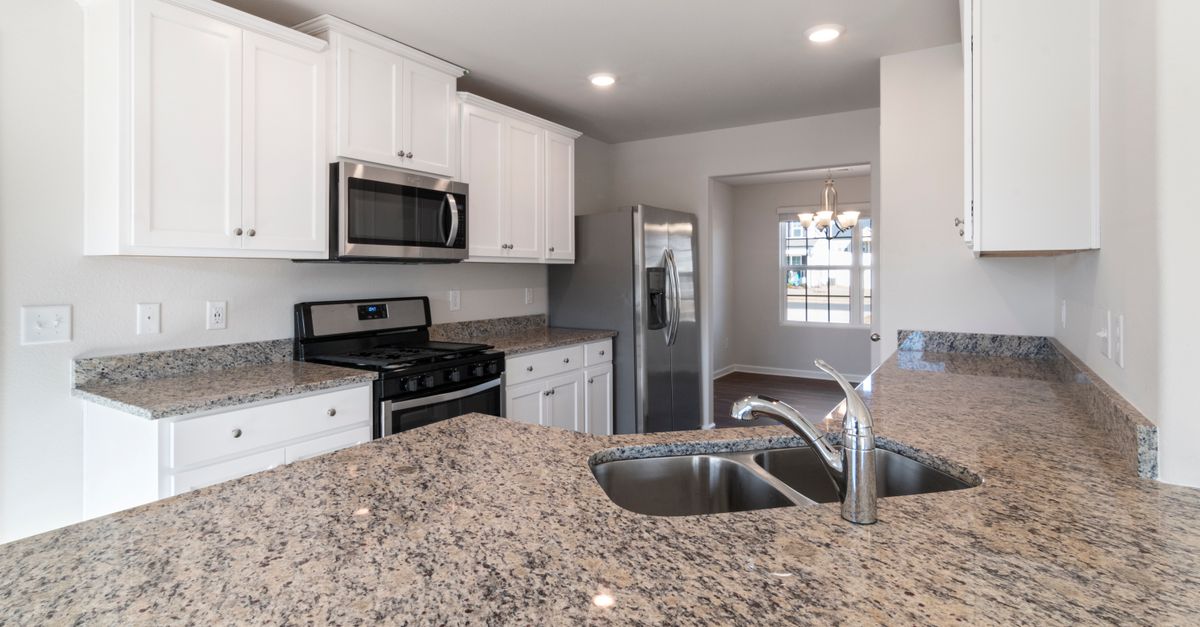 Sleek kitchen interior featuring granite countertops and stainless steel appliances.