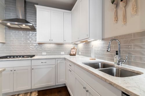 Free Sleek white kitchen with marble countertops and modern fixtures. Stock Photo