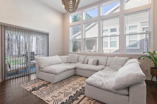 Spacious modern living room featuring a plush sectional sofa and large windows allowing natural light.