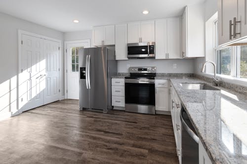 Kitchen Design with White Cabinets and Wooden Flooring