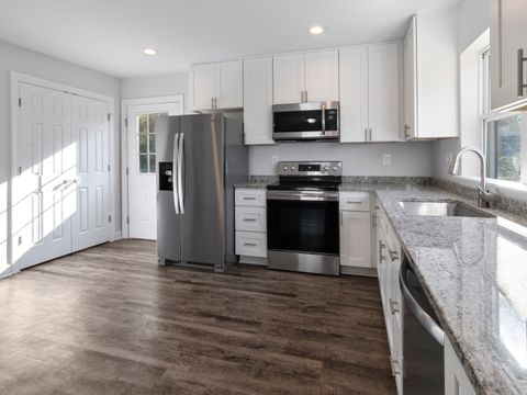 Bright kitchen with white cabinets and wood floors