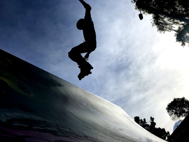 Silhouette Of Person With Roller Skates Jumping On Mid Air 