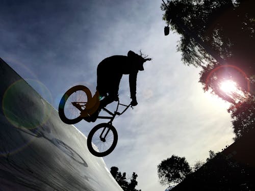 Free Silhouette of Person Riding on Bicycle Doing a Trick on Ramp Stock Photo