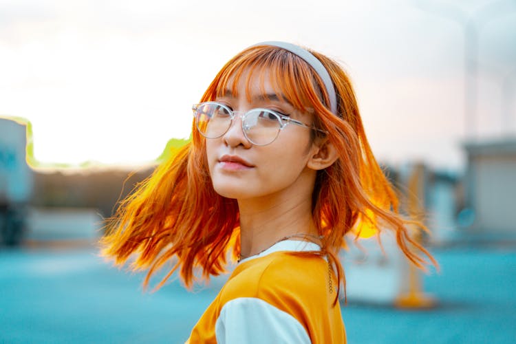 A Girl Wearing Eyeglasses With Orange Hair 