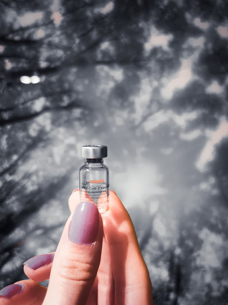 Hand Holding Vaccine Bottle