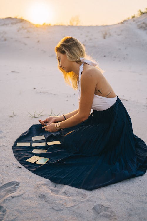 Free Woman Sitting On Sand With Tarot Cards On Her Skirt Stock Photo