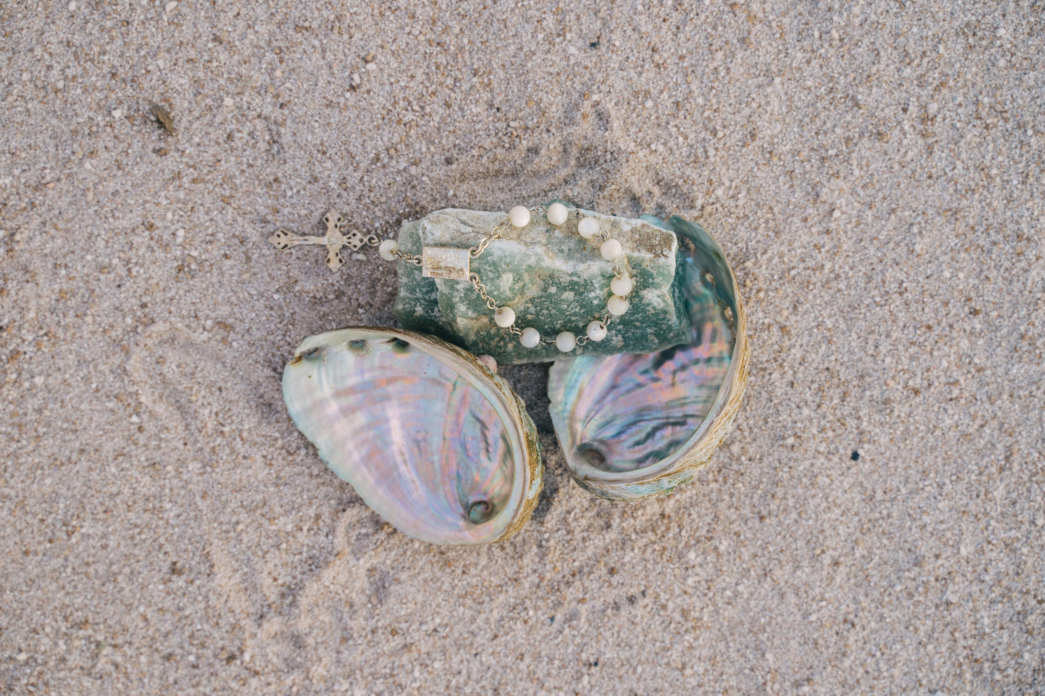 沙滩上色彩缤纷的贝壳中放置的念珠特写