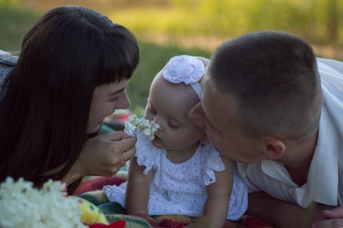 Parents Kissing Their Child