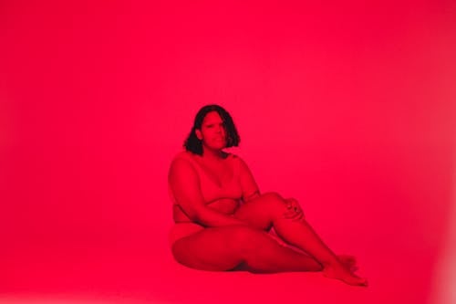 A Woman in Brown Tank Top Sitting on the Floor