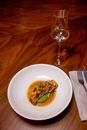 A Seared Tuna Dish Beside a Glass of White Wine