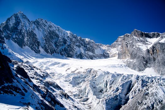 A breathtaking view of snow-capped mountains in Lijiang, Yunnan, China under a clear blue sky.