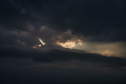 Moody sunset sky over Dali, China with dark clouds and sunlight breaking through.