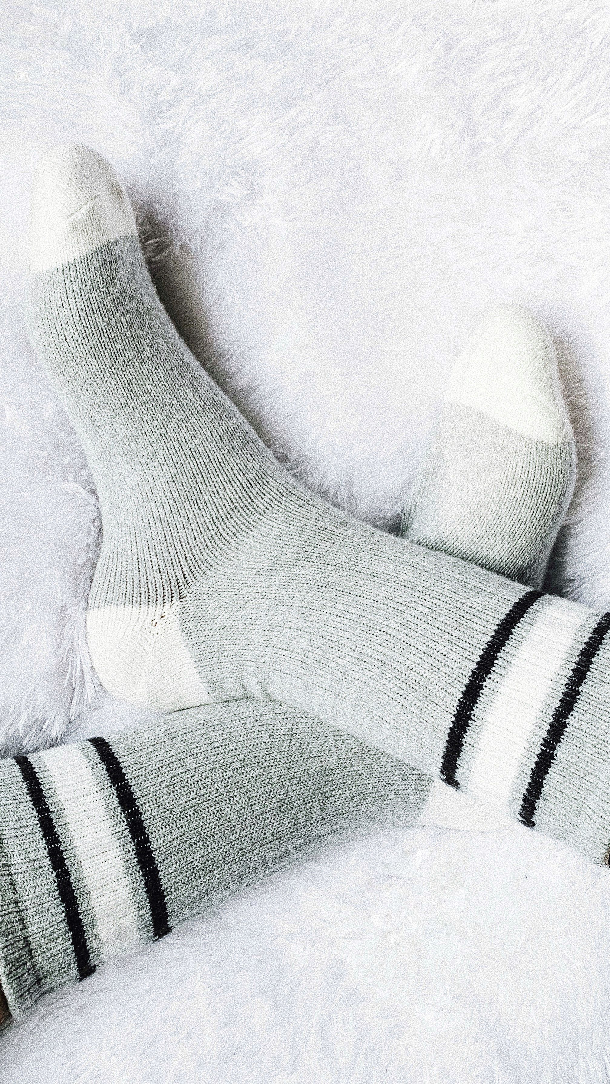 Cozy woolen socks resting on soft fabric, comfort and quiet encouragement