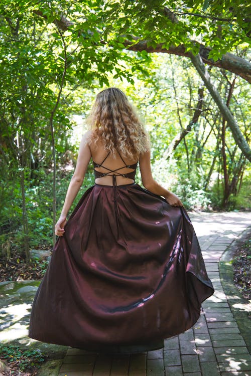 Back View of a Woman in a Long Dress at a Park