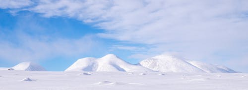 Snow Covered Mountain Under a Cloudy Sky