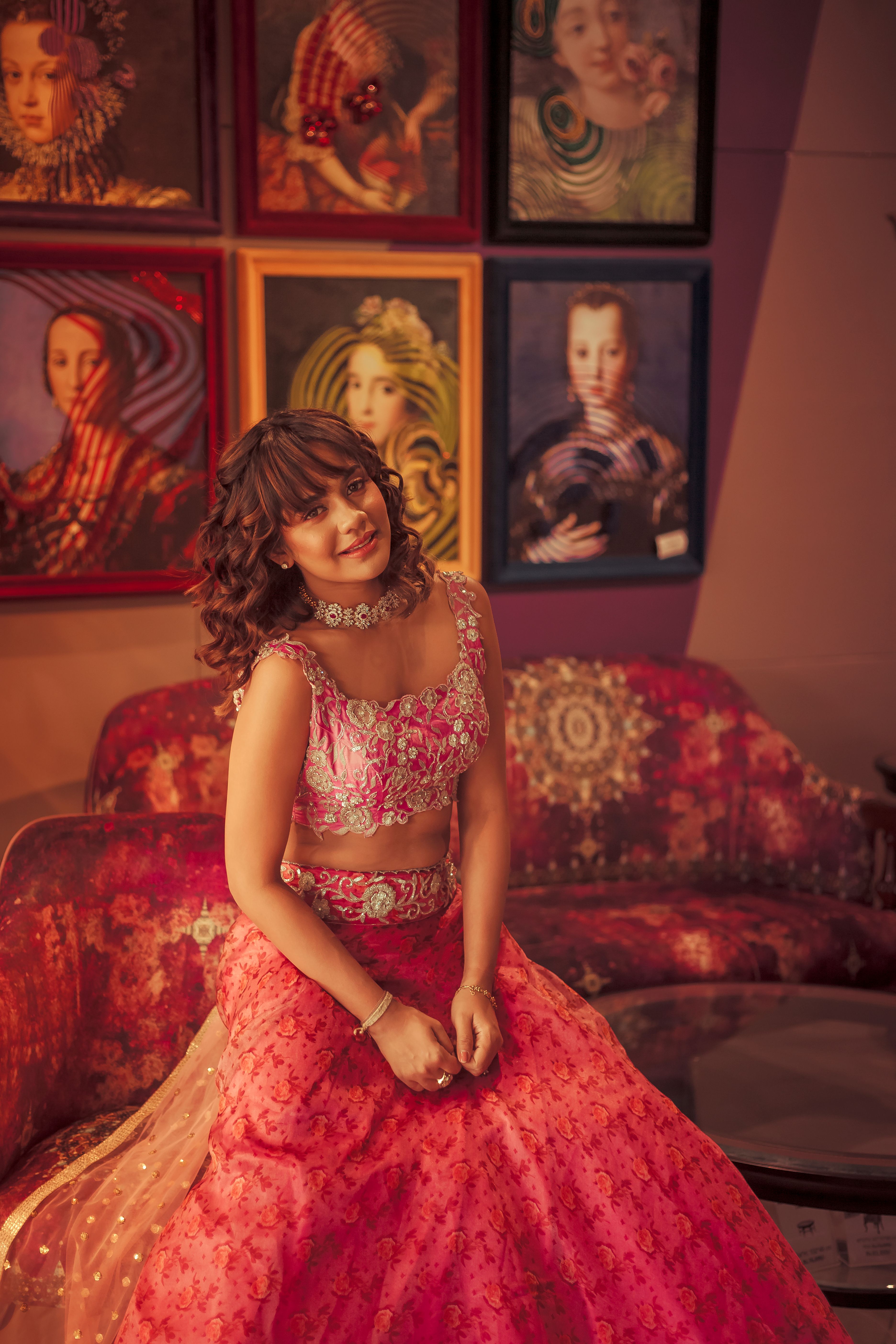 Fashionable woman sitting in vibrant indoor setting with modern art decor.