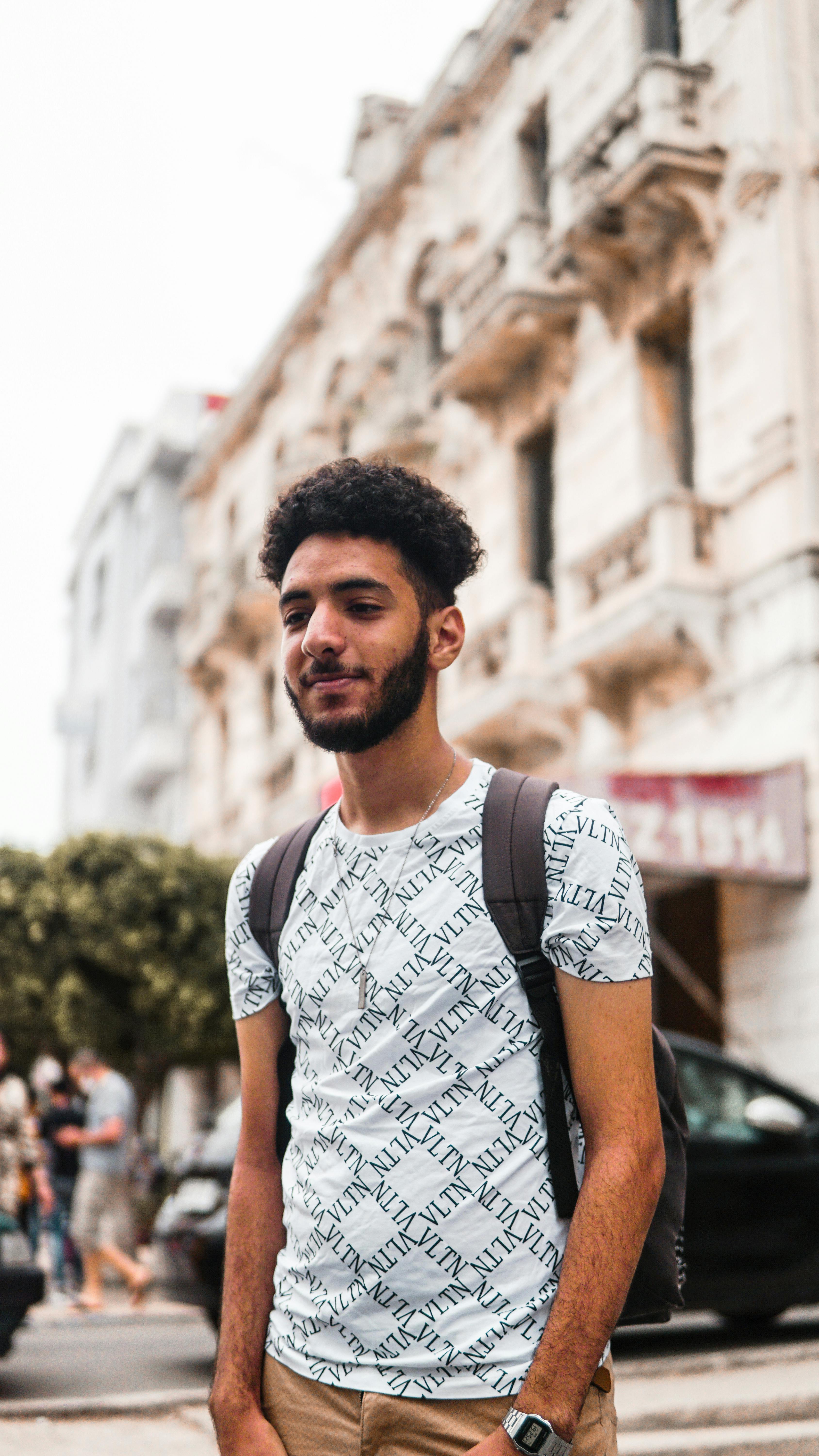 Portrait of a young man with a backpack in an urban street of El Jadida, Morocco.