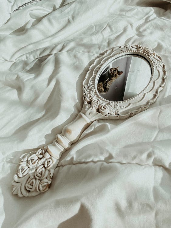 Free Victorian Hand Mirror on White Textile Stock Photo