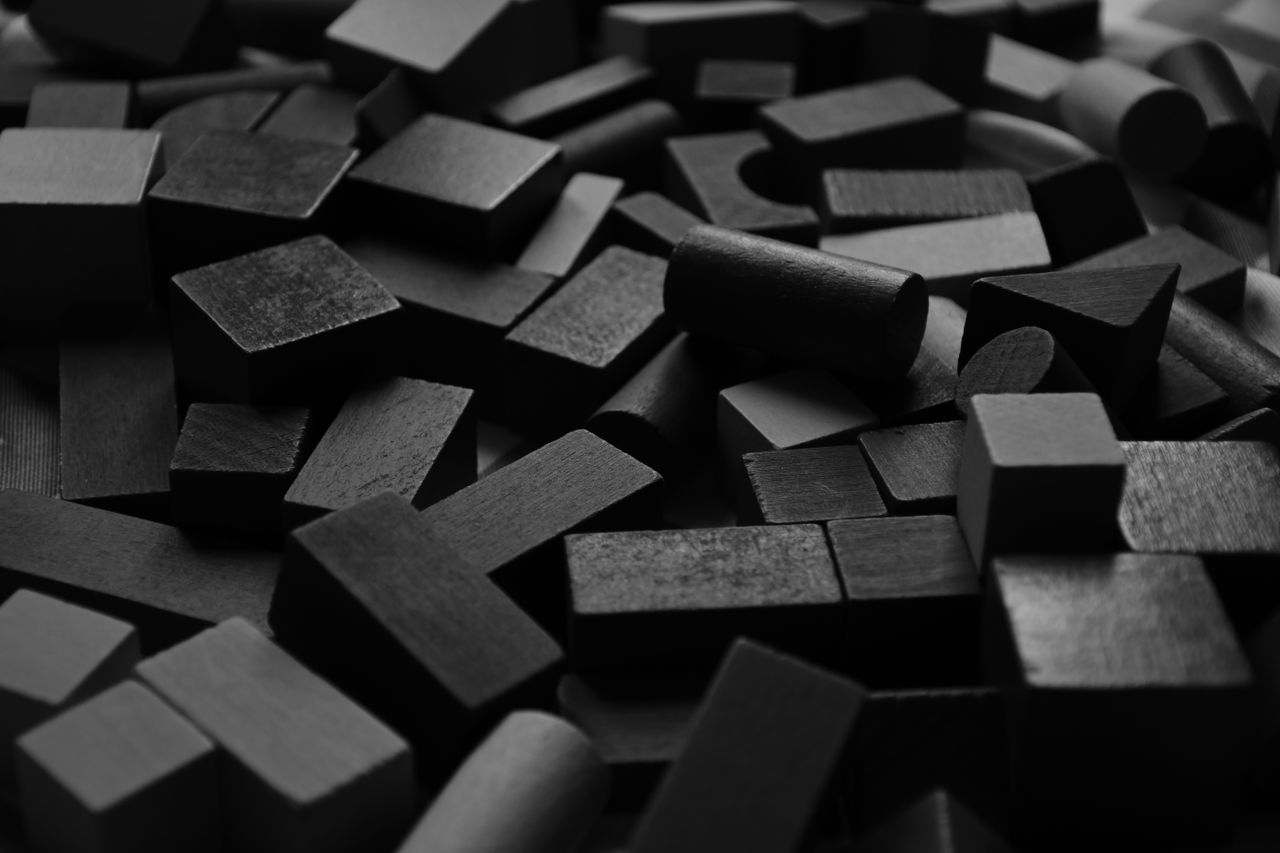 a close up view of black wooden blocks arranged randomly creating an a