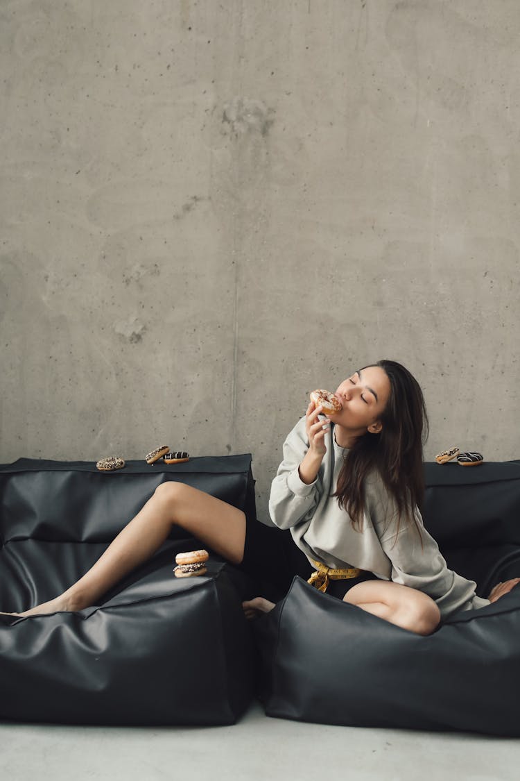 Photograph Of A Woman Eating A Donut