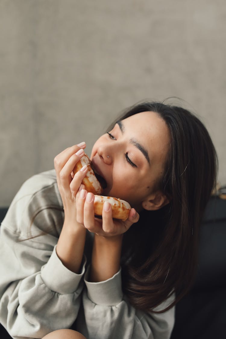 Close Up Of A Woman Eating Doughnuts 