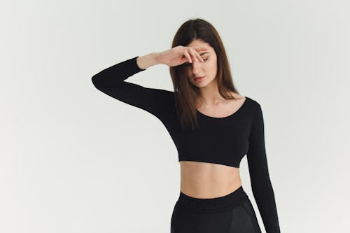Free Woman Wearing a Crop Top Looking Down Stock Photo